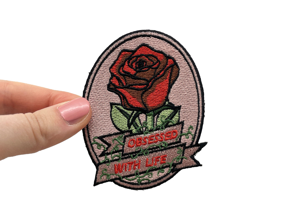 Frauenhand hält den Rote Rose Patch