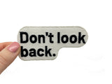 Frauenhand hält den Don´t look Back Patch