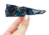 Frauenhand hält den Glasscherbe mit zwei Rosen Patch