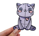 Frauenhand hält den Vodoo Katzen Patch
