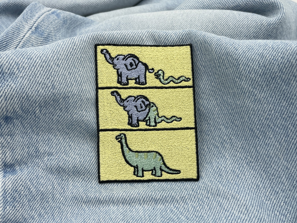 Dino Evolution Patch auf hellblauer Jeans
