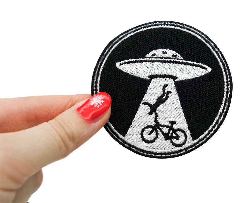 Frauenhand hält den Alien Invasion Patch