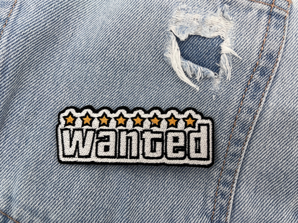 Wanted Patch auf löchriger hellblauer Jeans