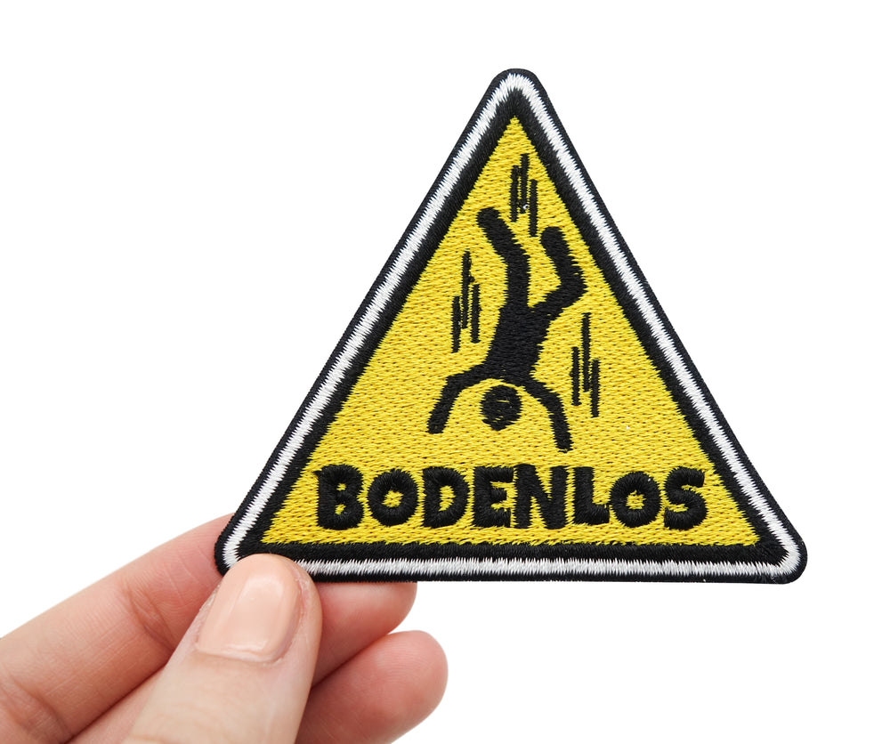 Frauenhand hält den Warndreieck Patch