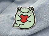 Grüner Frosch mit Herz Patch auf hellblauer Jeans