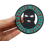 Skimasken Patch gehalten von einer Frauenhand