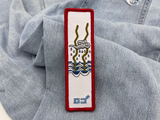 Wetter Klettpatch auf hellblauer Jeans
