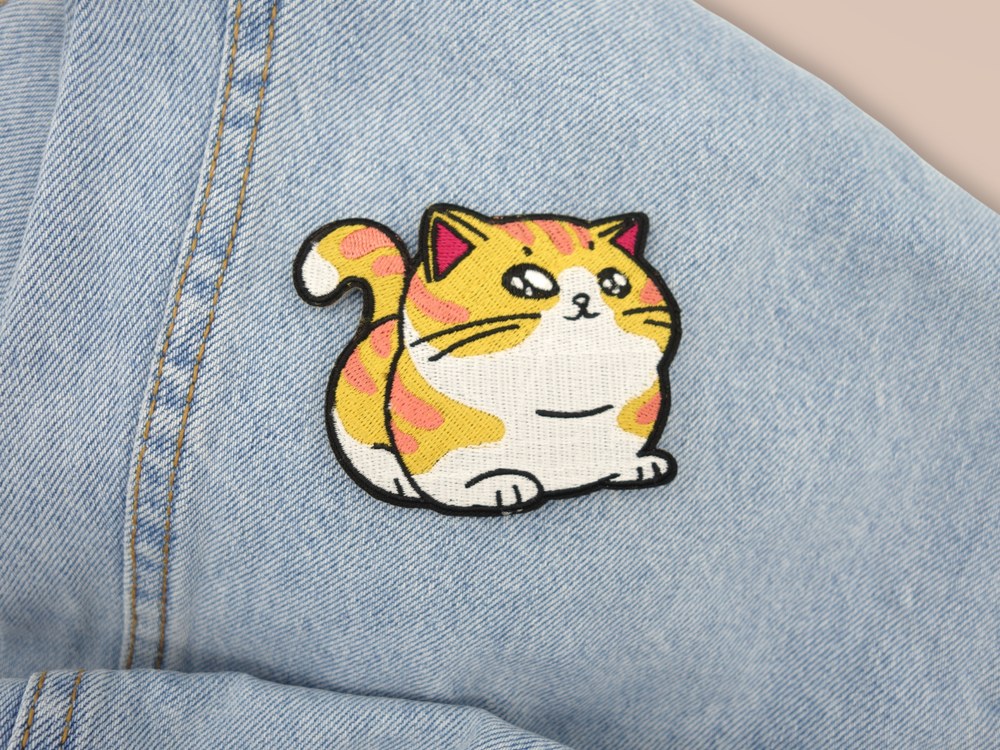 Dicke Katze Patch auf hellblauer Jeans aufgebügelt