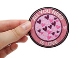 All you need is Love Patch gehalten von einer Frauenhand