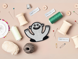 Lustiges Monster Patch mit Nähzeug im Hintergund