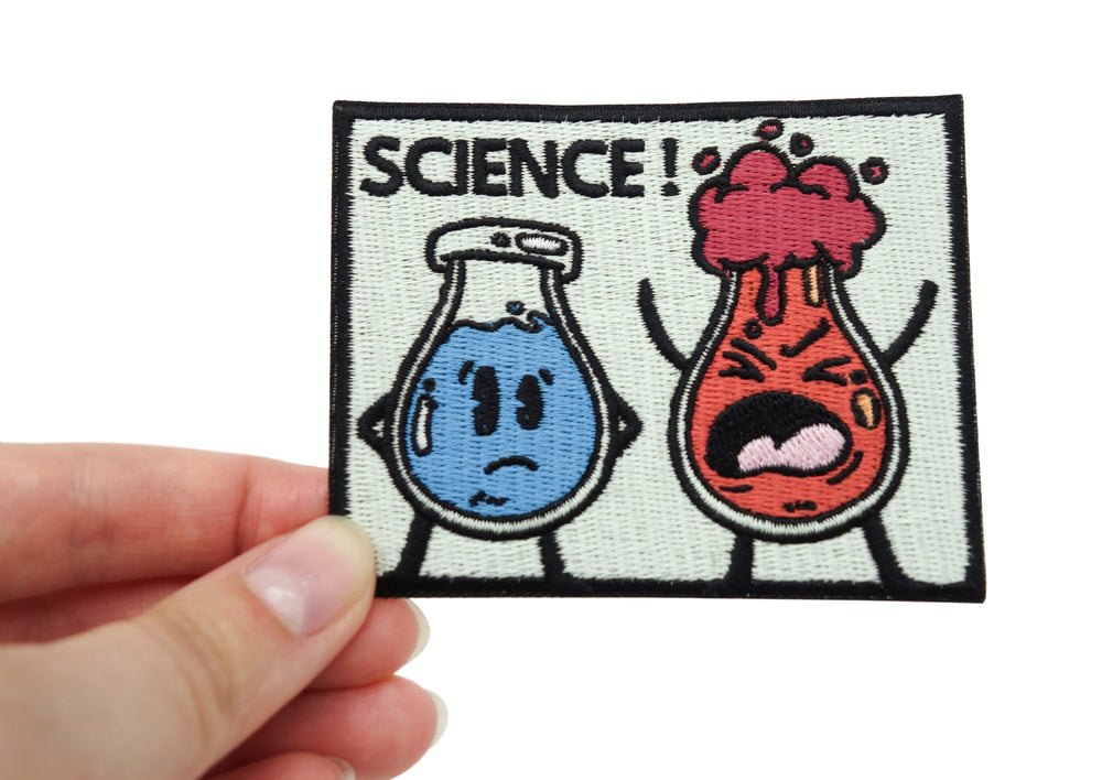 Frauenhand hält den Science! Patch
