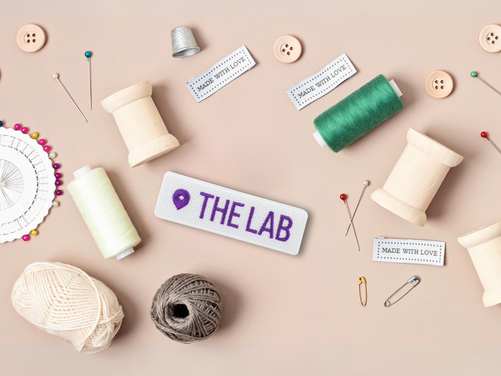 The Lab Standort Patch mit Nähzeug im Hintergrund