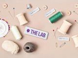 The Lab Standort Patch mit Nähzeug im Hintergrund