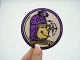 Wassermann Patch gehalten von einer Frauenhand