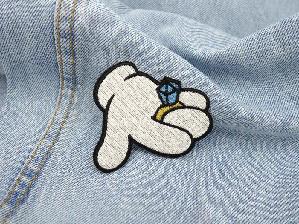 Cartoon Hand Patch auf hellblauer Jeans