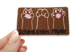 Pfoten Patch gehalten von einer Frauenhand