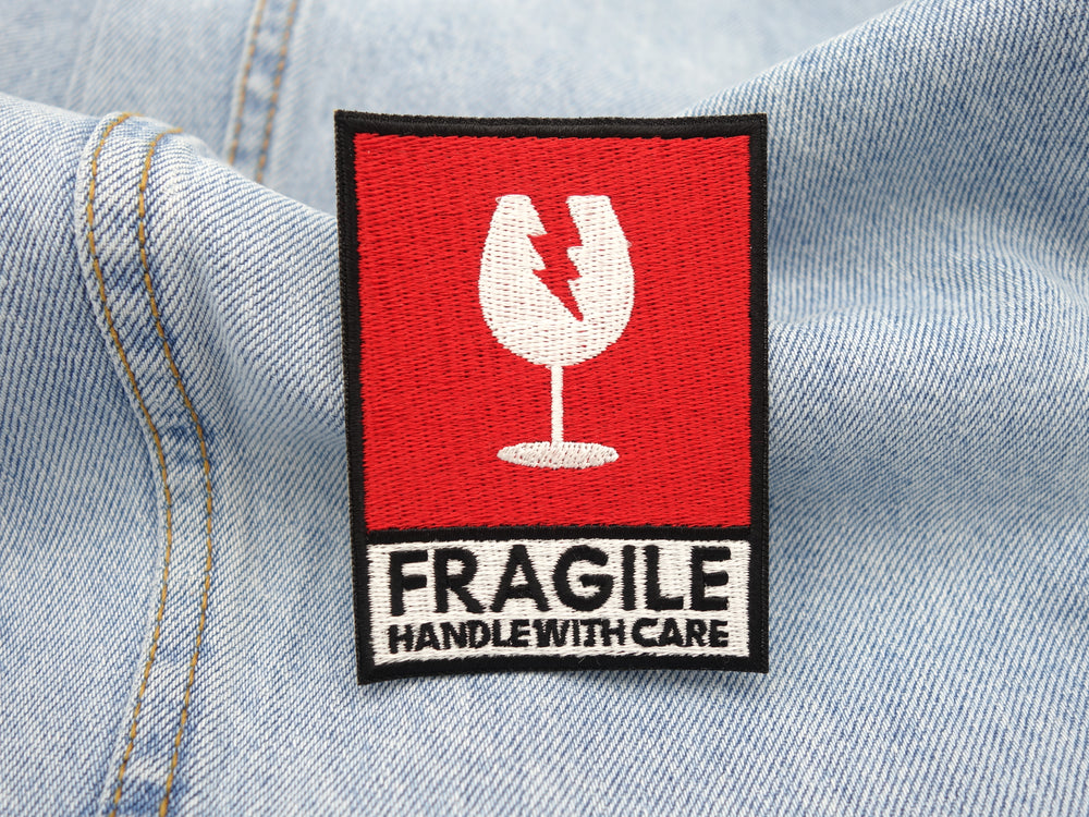 Fragile Patch auf hellblauer Jeans