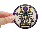 Skorpion Patch gehalten von einer Frauenhand