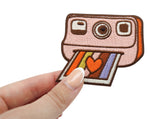 Frauenhand hält den Polaroid Patch