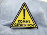Kommt Gefährlich Patch auf hellblauer Jeans