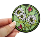 Frauenhand hält den grünen Blumen Patch