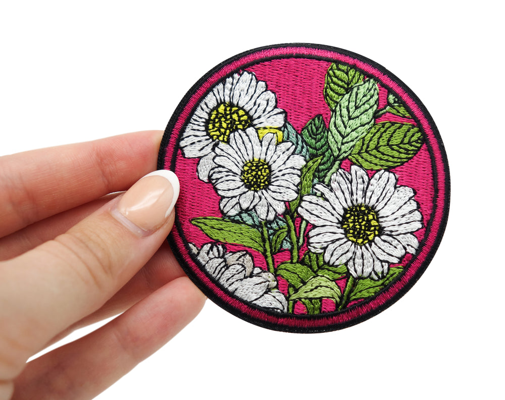 Frauenhand hält den roten Blumen Patch