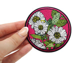 Frauenhand hält den roten Blumen Patch