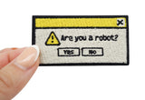 Frauenhand hält den Are you a robot? Patch
