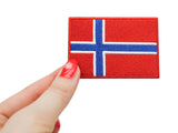 Frauenhand hält den Norwegen Klettpatch