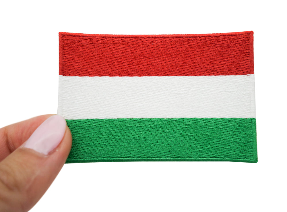 Frauenhand hält den Ungarn Flagge Patch