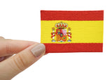 Frauenhand hält den Spanien Flaggen Patch