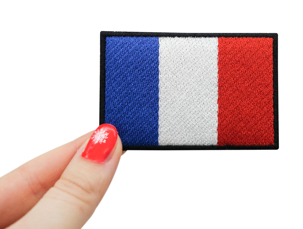 Frauenhand hält den Frankreich Flagge Klettpatch