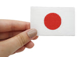 Japanischer Flaggen Patch in Frauenhand gehalten