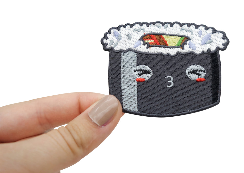 Hand hält schwarzen Kawaii Sushi Roll Patch