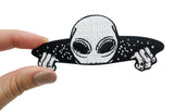 Frauenhand hält den Alien-Bügelpatch