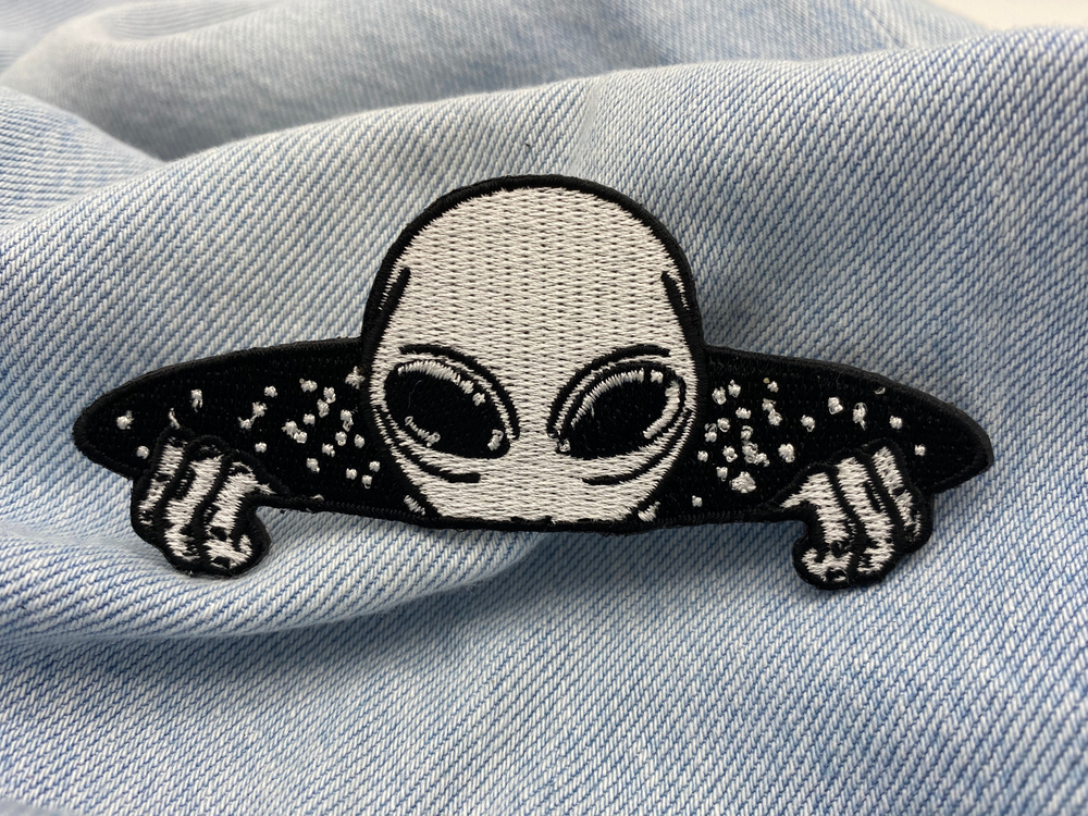 Alien-Patch auf blauer Jeans für den coolen Weltraum-Look