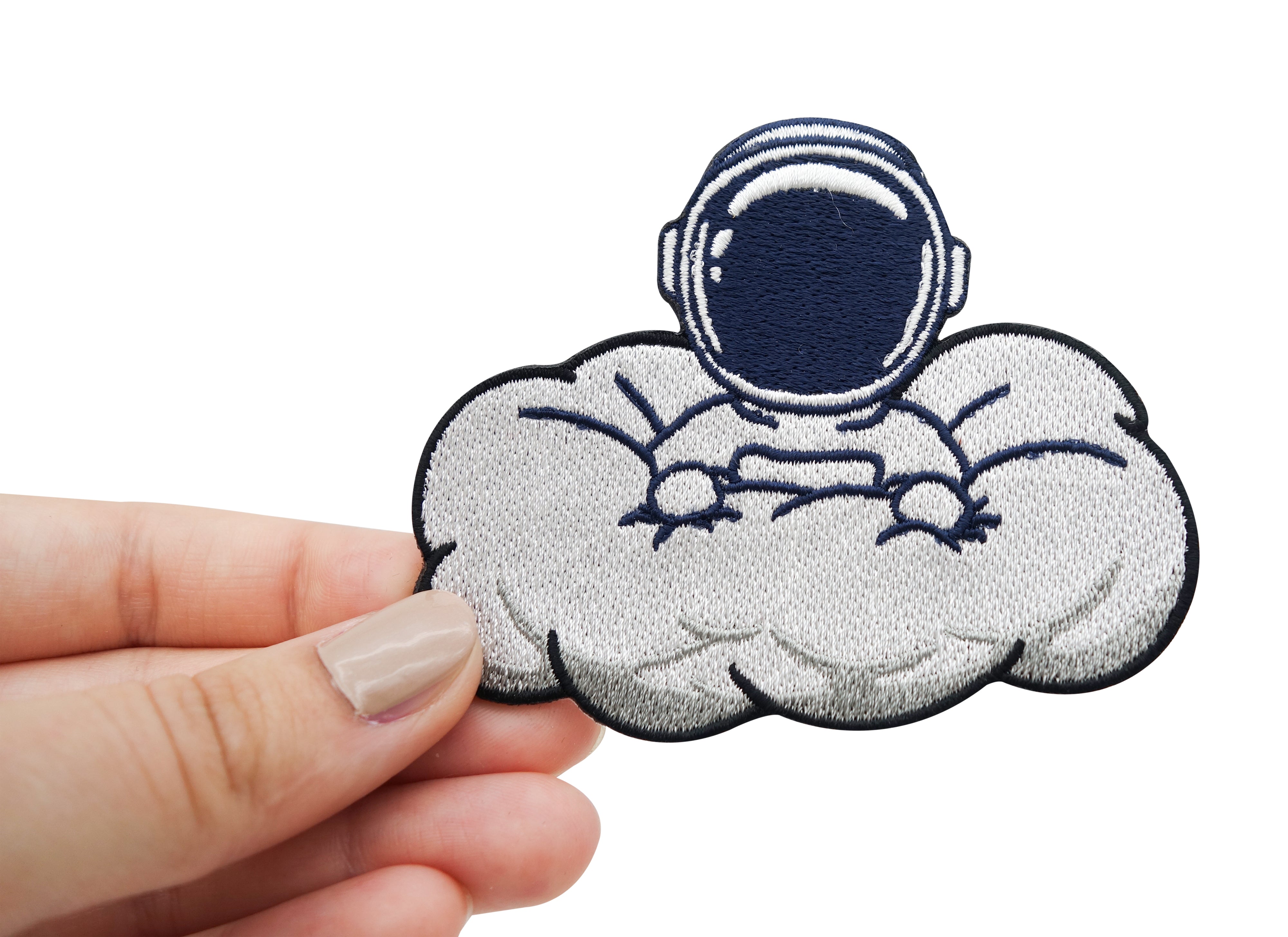 Frauenhand hält Patch Astronaut in Wolke