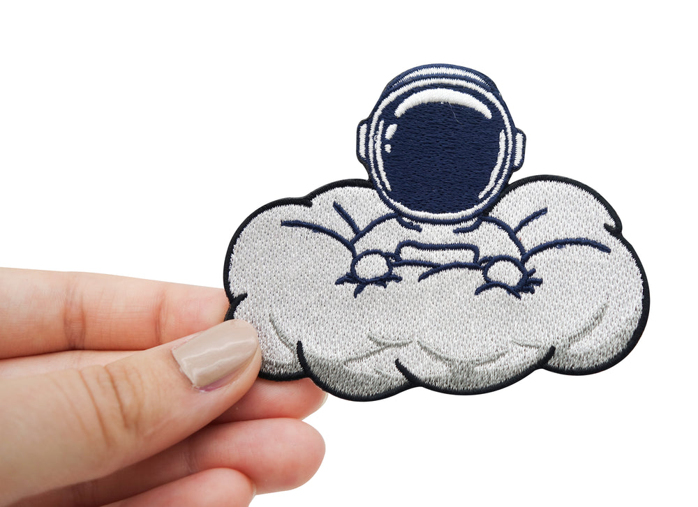 Frauenhand hält Patch Astronaut in Wolke