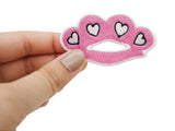 Frauenhand hält den rosa Schlagring-Patch