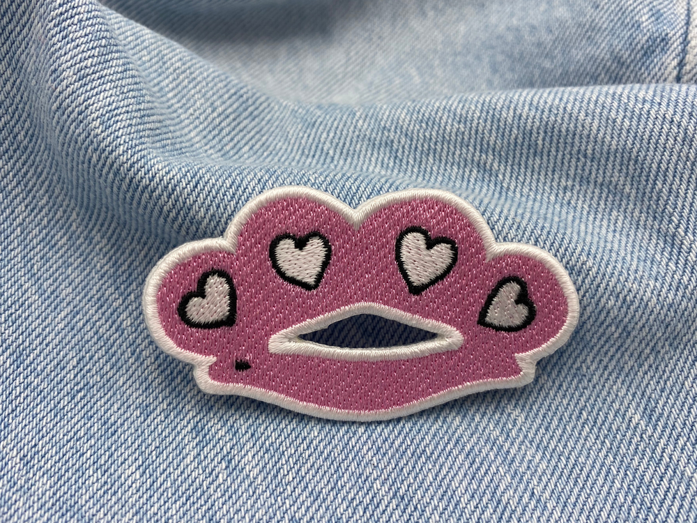 Rosa Schlagring-Patch auf blauer Jeans