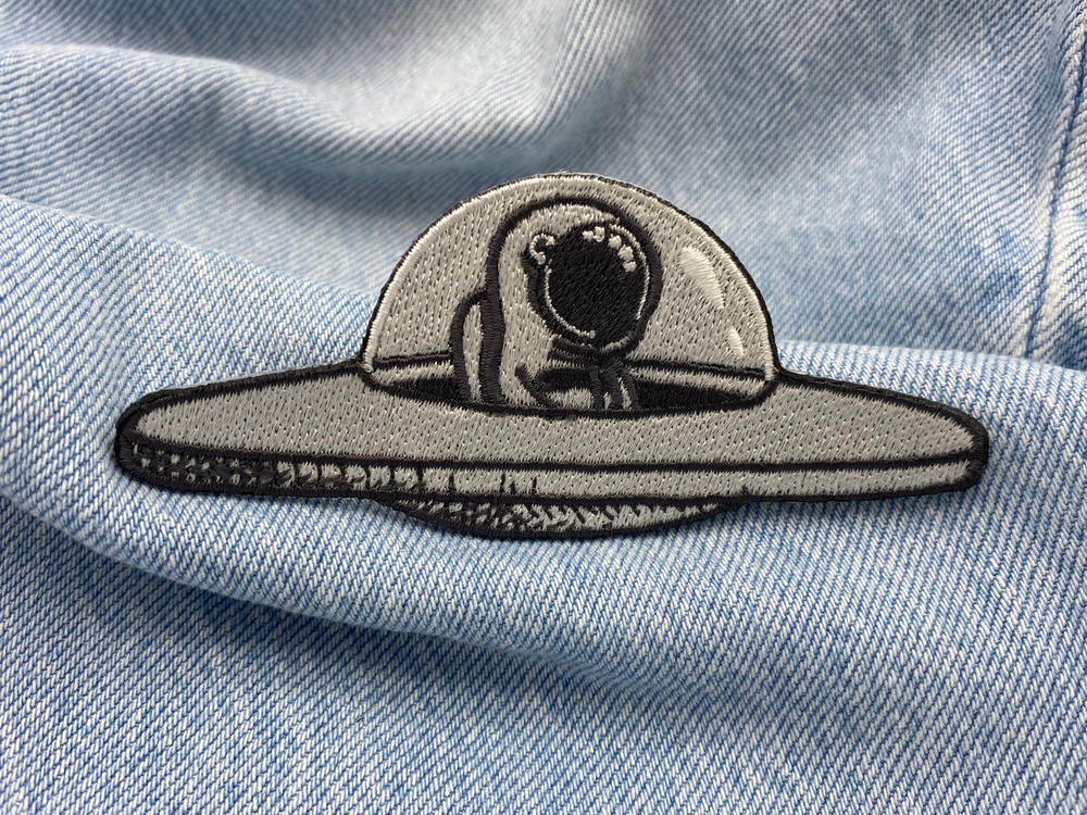 Astronauten-Patch auf blauer Jeans