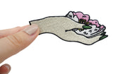 Frauenhand hält Blumenpatch