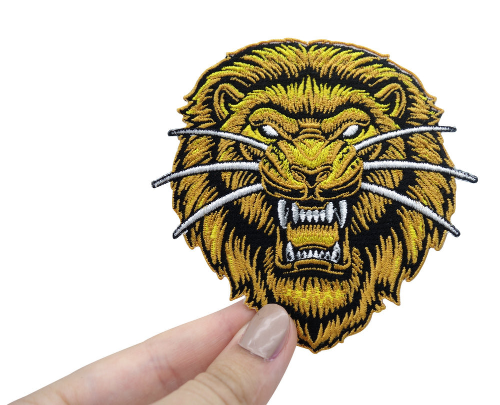 Frauenhand hält gelben Löwenkopf Patch
