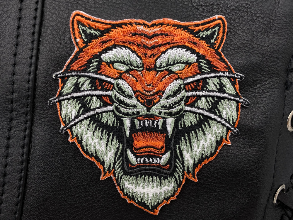 Tigerkopf Patch auf schwarzer Lederweste aufgebügelt