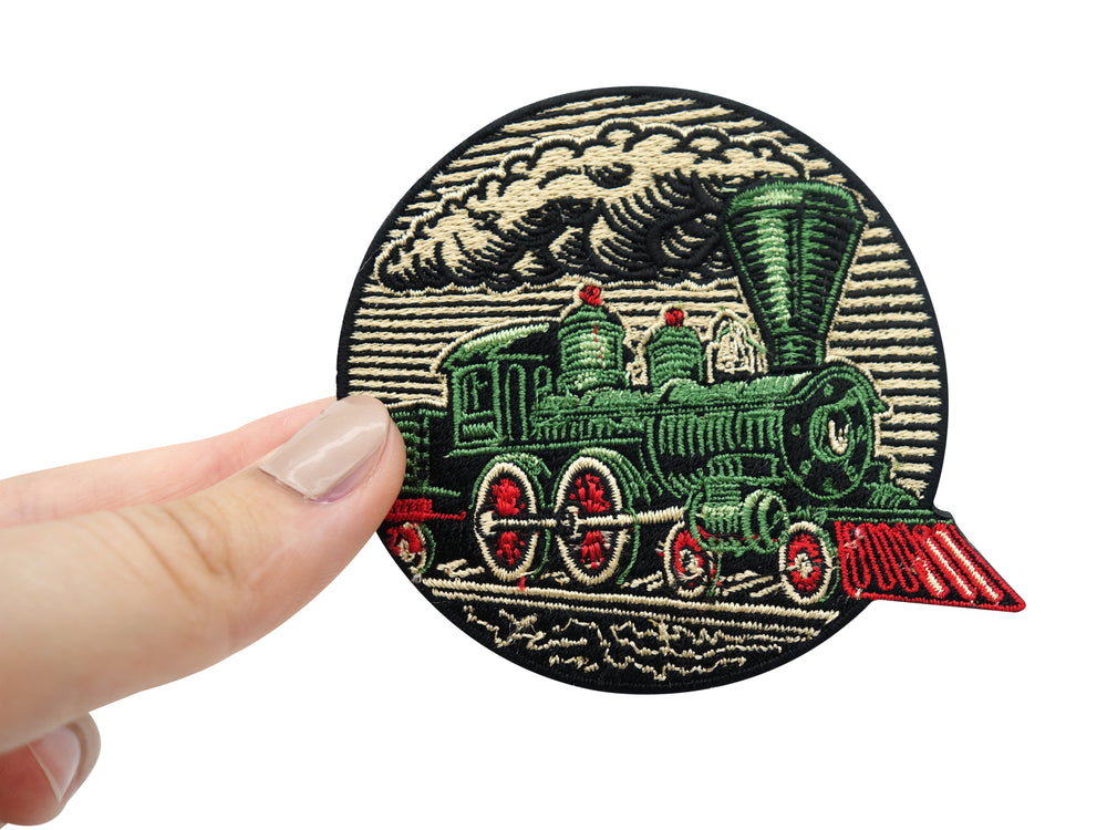 Frauenhand hält grünen Eisenbahn Zug Patch