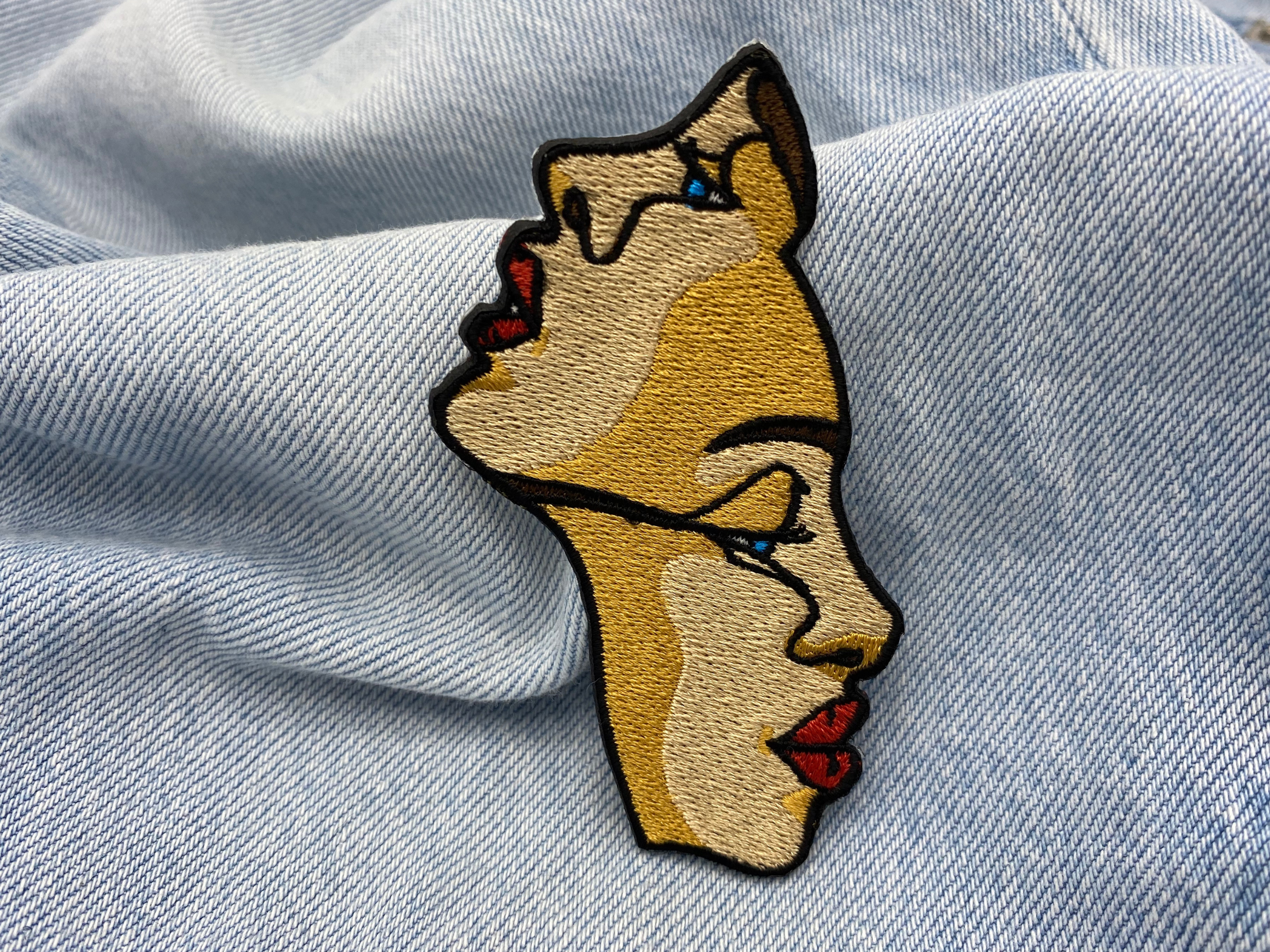 Beiger Line Art Bügelpatch auf blauer Jeans
