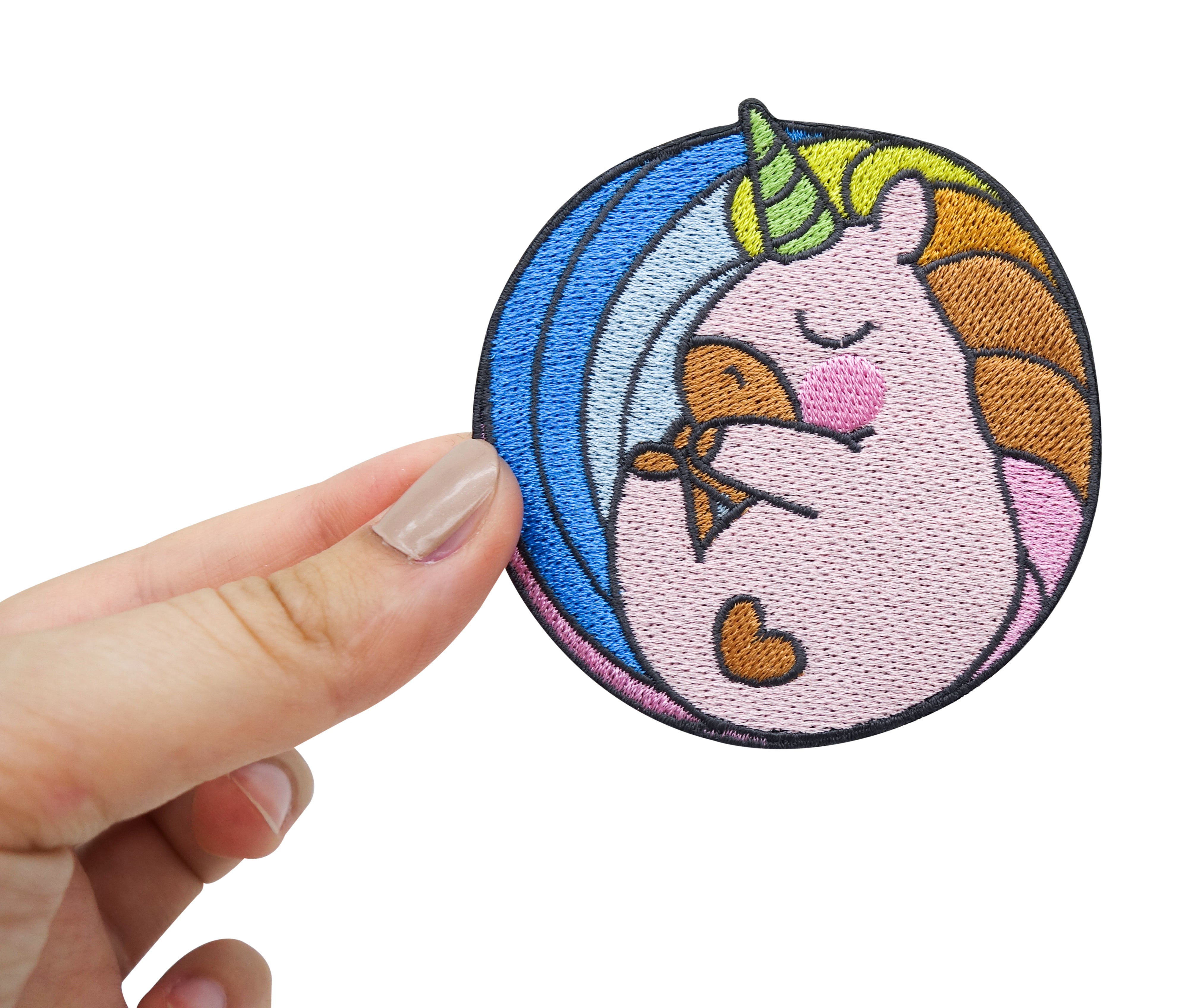 Baby Einhorn Patch gehalten von einer Frauenhand