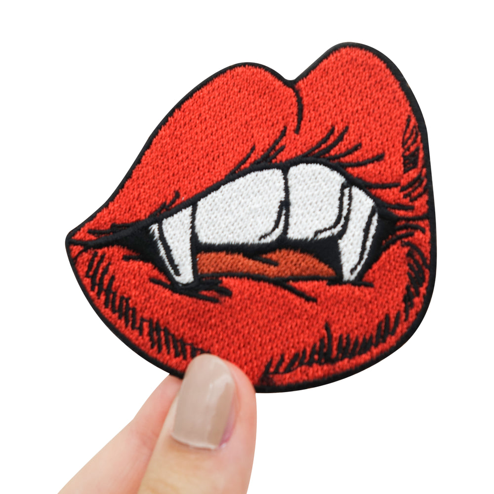 Frauenhand hält den Vampir Kussmund Patch 