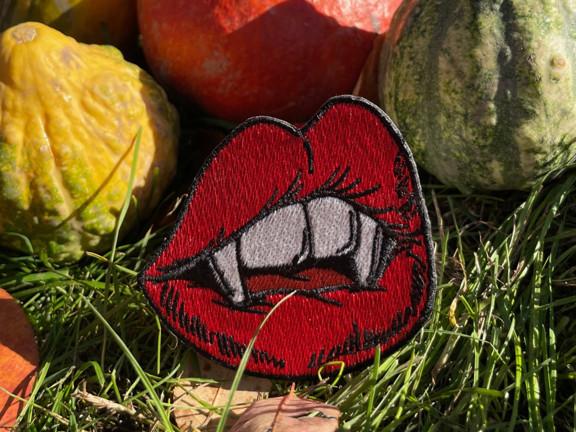 Vampir Kussmund Patch mit Kürbissen im Hintergrund 