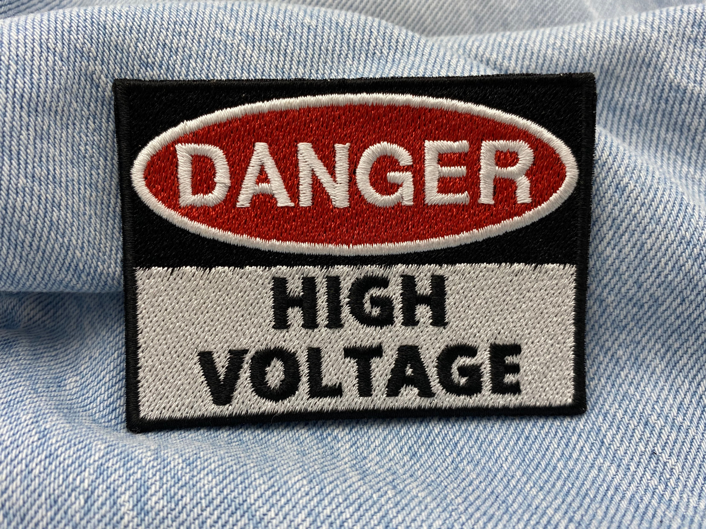 High Voltage Patch auf blauer Jeans 